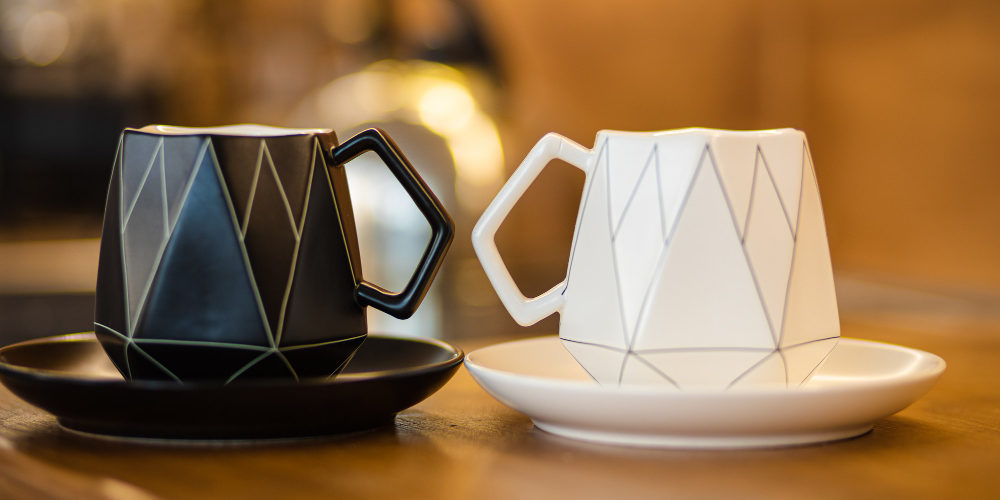 Modne kubki do kawy i herbaty w różnych kolorach i stylach, ustawione na stole