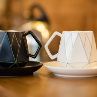 Modne kubki do kawy i herbaty w różnych kolorach i stylach, ustawione na stole