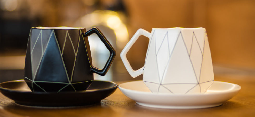 Modne kubki do kawy i herbaty w różnych kolorach i stylach, ustawione na stole